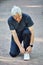 Elderly man wear sportivewear ties shoelaces ready for jogging