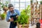 An elderly man wearing handsome glasses and a beard enjoys taking care of trees, pruning trees with scissors as a hobby, home