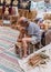 Elderly man weaves chair at the fair