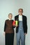 Elderly man and woman in art performance, replica of painting american gothic. Retro style, comparison of eras and