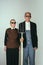 Elderly man and woman in art performance, replica of painting american gothic. Retro style, comparison of eras and