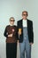 Elderly man and woman in art performance, replica of painting american gothic. Retro style, comparison of eras and