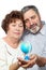 Elderly man and woman look at small globe