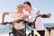 Elderly man with woman in white shirts walking with bicycles on