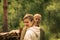 An elderly man and a young woman communicate and talking against the background of nature