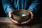 Elderly mans hands clutch empty bowl on wooden surface, representing hunger and poverty