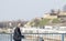 Elderly men wearing protective mask walking alone city bridge with Kalemegdan fortress in the background