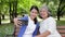 Elderly mother and Asian daughter lounging in the park Happy on vacation