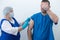 elderly nurse gives injection to man  vaccination