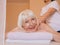 Elderly old caucasian stylish woman with gray hair laying on a massage.