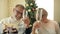 Elderly parents wish their children and grandson, who live far away, Merry Christmas. Family video call concept.