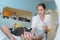 Elderly patient laying in bed with caring young female nurse