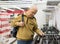 Elderly pensioner looks at a gas stove on the counter in a store