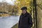 Elderly pensioner stands on beautiful autumn day in city park