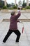 Elderly performing tai chi with sword in winter