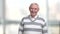 Elderly person is laughing, blurred background.