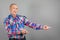 The elderly person point away. Serious Mature man pointing finger to the side, on grey background, copy space