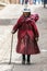 An elderly Peruvian woman walks down a street in the town of Maras in Peru.