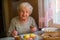 Elderly positive woman dines at home.