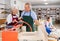 Elderly potter teaches woman how to roll clay on a craft machine clay press roller