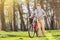 An elderly pushing his bike in the park