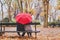 Elderly retired couple sitting together on the bench in autumn park, love concept