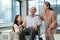 Elderly retirement father laugh and happy sitting on wheel chair with his wife and daughter. Daughter caregiver take care senior