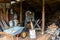 An elderly Russian man hunched wearily chopping wood with an axe in a barn