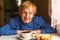 An elderly russian woman drinking tea at kitchen