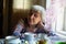 Elderly russian woman sitting in the kitchen.