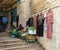 An elderly saleswoman sells vegetables and clothes on the steps in the Nativity Street in Bethlehem in the Palestinian Authority,