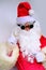 Elderly santa claus in a suit, with a white beard congratulates children and adults, shows with his hands, the concept of