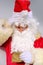 Elderly santa claus in a suit, with a white beard congratulates children and adults, shows with his hands, the concept of