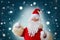 Elderly santa claus in a suit, with a white beard congratulates children and adults, shows with his hands, the concept of