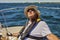 An elderly seafarer manages a sailing boat on a sunny summer day.