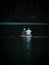 Elderly senior couple in wooden rowing paddle boat on calm alpine mountain lake Gleinkersee in Upper Austria alps Europe