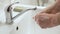 Elderly senior man washing his hands under tap water faucet, closeup detail - hygiene during coronavirus covid-19 outbreak
