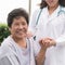 Elderly senior patient Asian old aging person in nursing hospice home holding geriatrician doctor`s hand having happy health