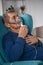 Elderly senior sits in a armchair with an oxygen mask in quarant