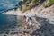 Elderly senior traveling backpacker mature woman tourist taking photos sea coast, rocks, blue sky