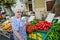 Elderly senior woman buying fresh vegetables and fruits in farmer`s market during summer day in provence france