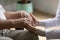 Elderly sick male palms in hands of supportive female doctor