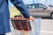 Elderly single man in a blue suit walks to his car with a supermarket trolley. Businessman and shopping.