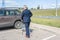 Elderly single man in a blue suit walks to his car with a supermarket trolley. Businessman and shopping.