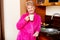 Elderly smile woman drinking coffee or tea in her kitchen