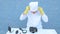 Elderly solid person in white dressing gown, cap, medical mask, glasses cleans matrix of digital camera with special means. Lens,