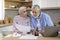 Elderly Spouses Calculating Family Expenses While Sitting On Table In Kitchen