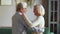 Elderly spouses talking dancing waltz in living room