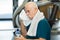 Elderly tired man in gym with towel