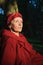 Elderly tired woman in red clothes in park sitting on the bench and enjoying a good weather and sunset in the park